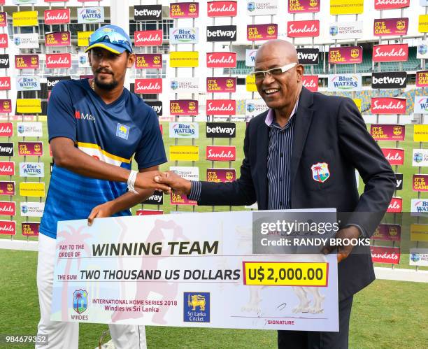 Suranga Lakmal of Sri Lanka receives the winners cheque from Calvin Hope at the end of day 4 of the 3rd Test between West Indies and Sri Lanka at...