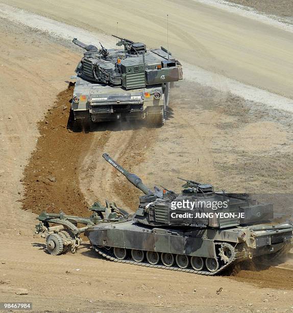 Abrams tanks clear the ground in a mine-sweeping operation during a joint gunnery exercise at a military firing range in Pocheon, near the...