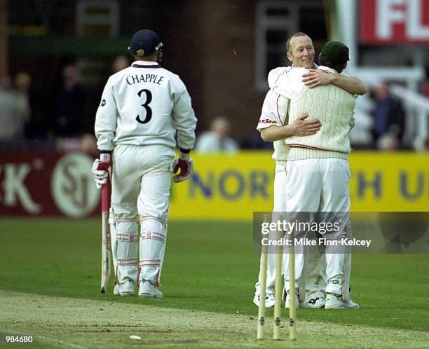 Vince Wells, captain of Leicestershire, celebrates with team-mate neil Burns after dismissing Glenn Chapple of Lancashire for 8 in the Benson &...