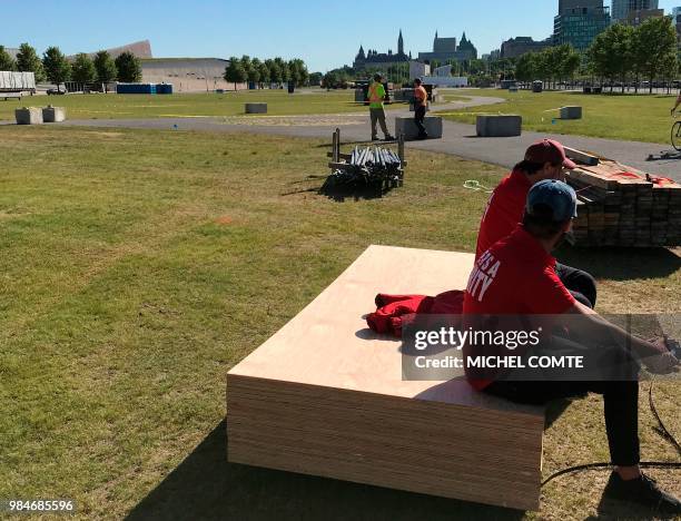 Construction crews sit idle near a pedestrian roundabout at an outdoor venue in Ottawa, Canada, June 26, 2018 less than two weeks before the start of...