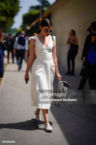 Guest wears a white dress, outside Balmain, during Paris Fashion Week - Menswear Spring-Summer 2019, on June 24, 2018 in Paris, France.