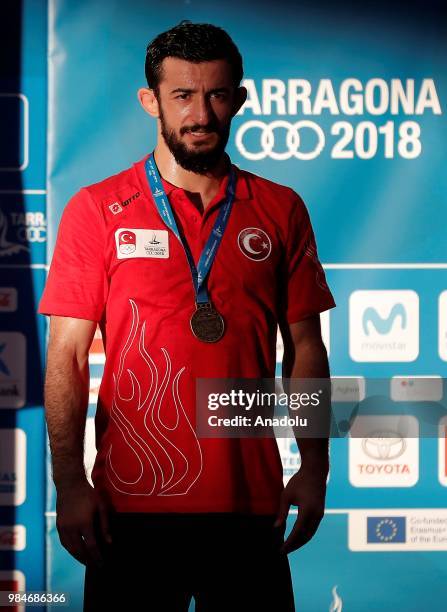 Gold medalist Selahattin Kilicsallayan of Turkey poses for a photo after winning against David Habat of Slovenia in 65kg Men's Freestyle Wrestling...