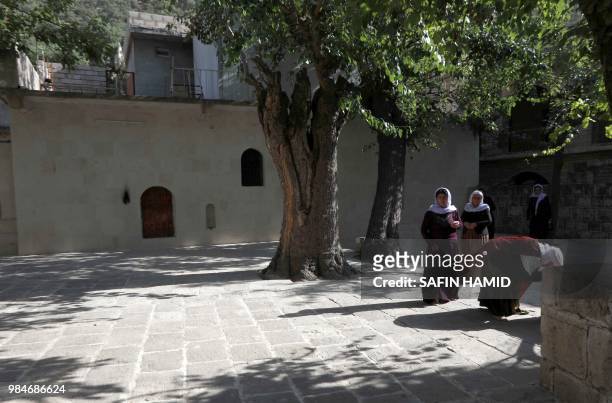 Iraqi Yazidi women gather at Lalish temple in a valley near Dohuk, 430 km northwest of the capital Baghdad, on June 24, 2018. At the Yazidis' most...