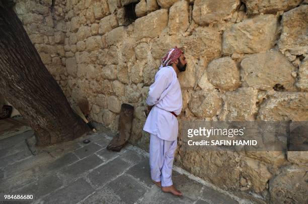 An Iraqi Yazidi man stands outside Lalish temple in a valley near Dohuk, 430 km northwest of the capital Baghdad, on June 24, 2018. At the Yazidis'...