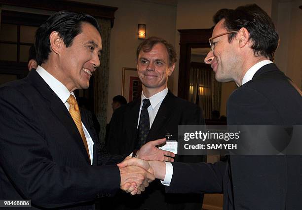 Taiwan President Ma Ying-jeou shakes hands with Phil Chetwynd, chief Asia editor for AFP as Peter Harmsen , Taipei Bureau Chief of AFP looks on...