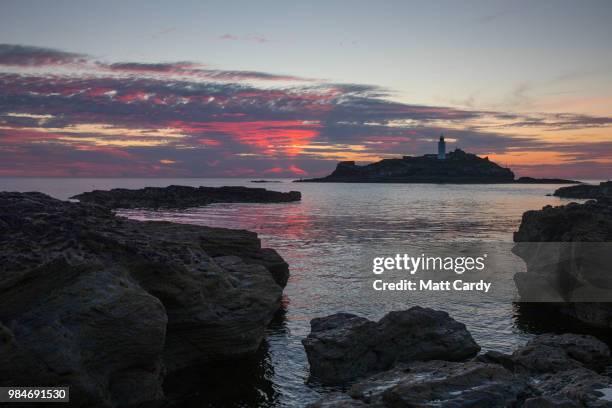 The sun sets at Godrevy Lighthouse near Gwithian on June 26, 2018 in Cornwall, England. Parts of the UK are currently basking in heatwave...