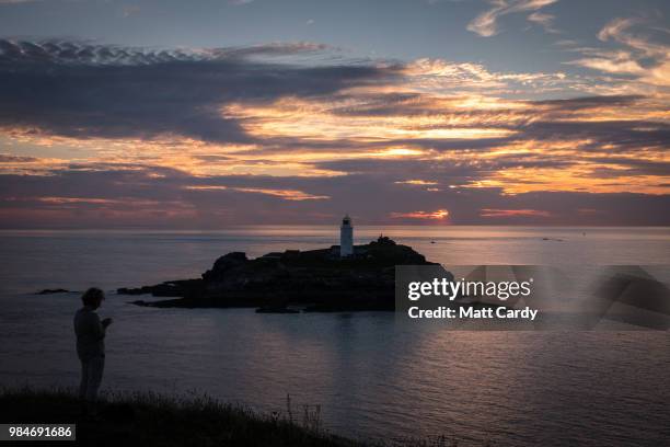 The sun sets at Godrevy Lighthouse near Gwithian on June 26, 2018 in Cornwall, England. Parts of the UK are currently basking in heatwave...