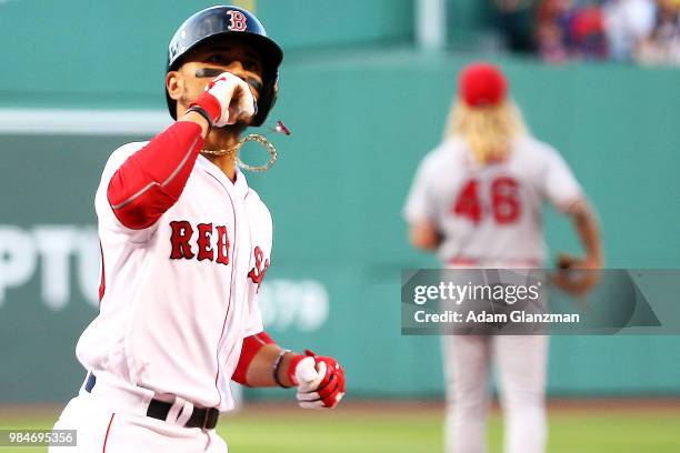 John Lamb of the Los Angeles Angels looks on as Mookie Betts of the Boston Red Sox reacts as he crosses home plate after hitting a solo home run in...