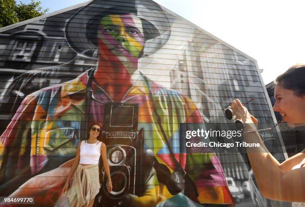 Mia Smiley, left, poses for a photo by her friend Lauren Grabos, next to a Vivian Maier mural painted by revered Brazilian artist Eduardo Kobra in...