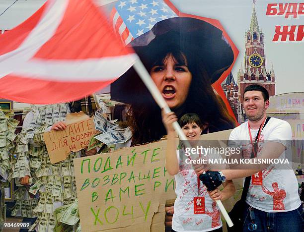 Members of the pro-Kremlin youth group Nashi wave their flag during their fifth congress in Moscow on April 15, 2010. AFP PHOTO / NATALIA KOLESNIKOVA