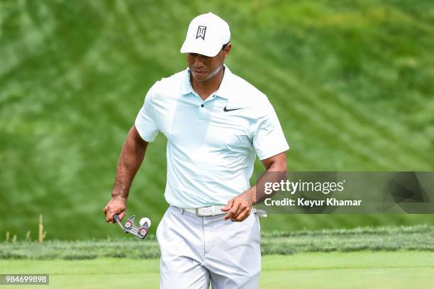 Tiger Woods uses a TaylorMade Ardmore 3 mallet putter to grab his ball on the 16th hole during practice for the Quicken Loans National at TPC Potomac...