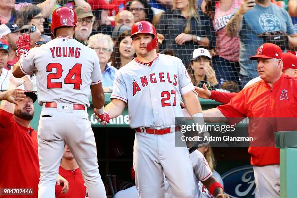 Chris Young high fives Mike Trout of the Los Angeles Angels after hitting a solo home run in the third inning of a game against the Boston Red Sox at...
