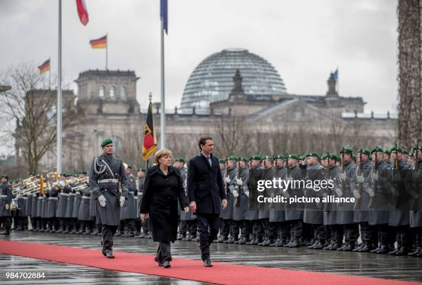 German Chancellor Angela Merkel and Austrian Chancellor Sebastian Kurz, inspect the guard of honour during his reception at the German Chancellery in...