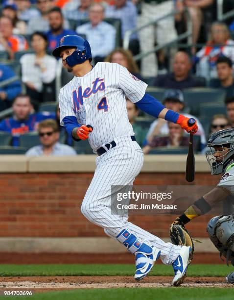 Wilmer Flores of the New York Mets fiollows through on a first inning two run single against the Pittsburgh Pirates at Citi Field on June 26, 2018 in...