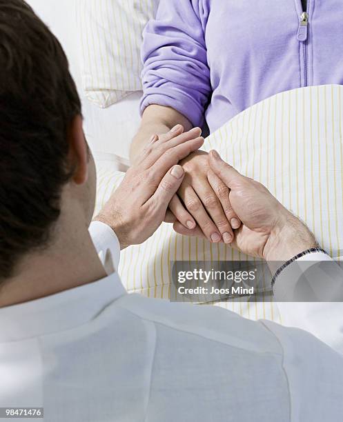 doctor holding females patient hand - newhealth stockfoto's en -beelden