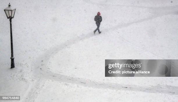 Dpatop - A man walks along an iced and snowy pathway in Irsee, Germany, 17 January 2018. Photo: Peter Kneffel/dpa