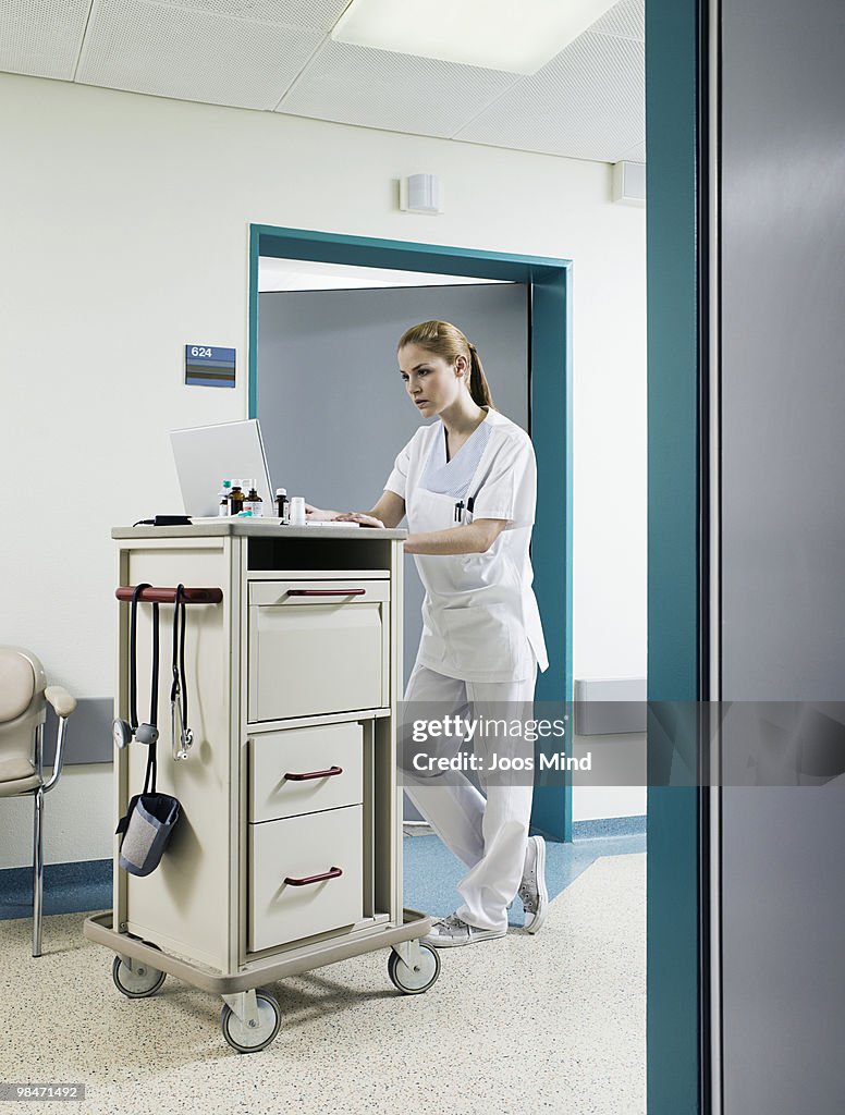 Nurse using laptop to serve medicine