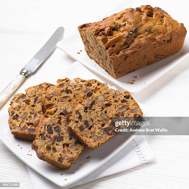 slices of date and walnut cake with cake and knife - viereckiger teller stock-fotos und bilder