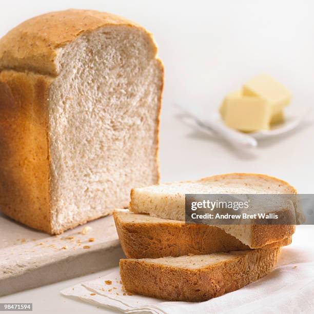 wheat bran loaf with slices and butter pats - pats stock pictures, royalty-free photos & images