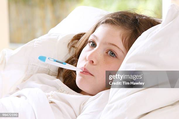 girl in bed with thermometer in mouth - carrying in mouth stock pictures, royalty-free photos & images