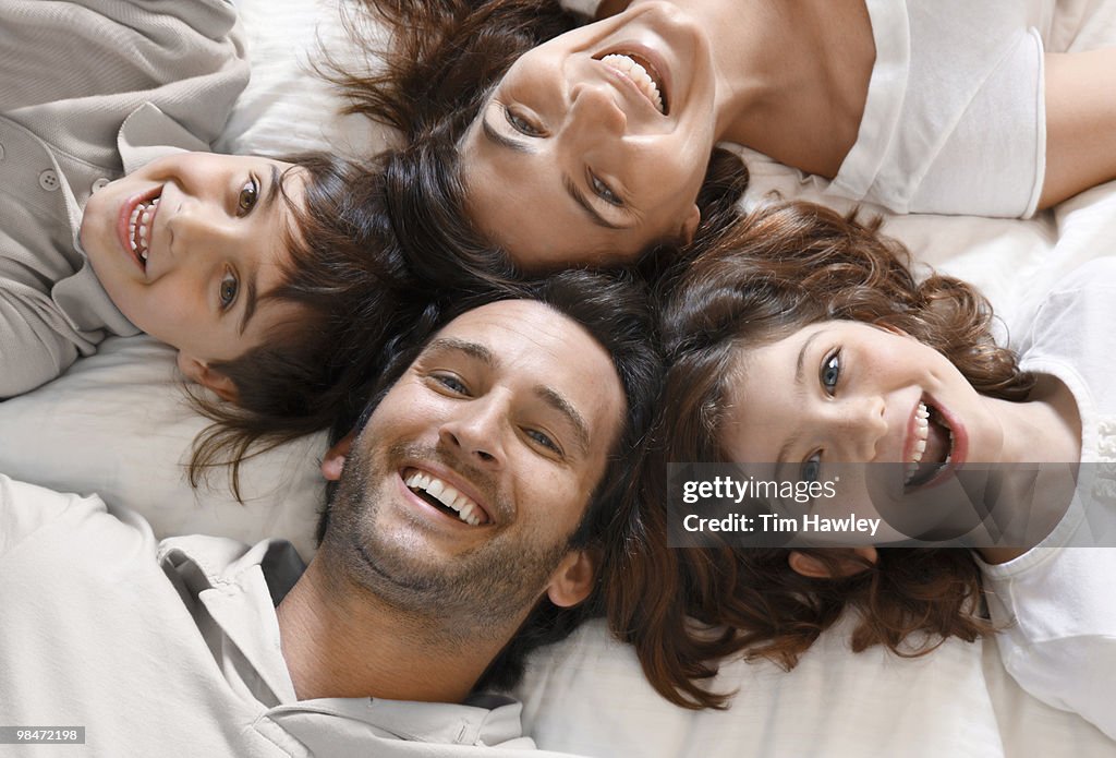 Happy family of 4 smiling at camera