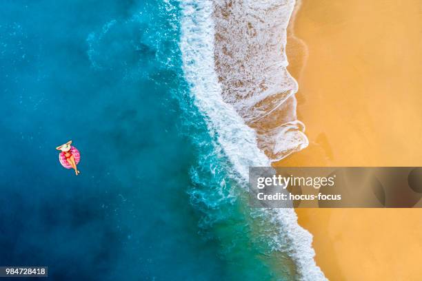 schwimmen im klaren, türkisfarbenen meer - luftmatraze stock-fotos und bilder