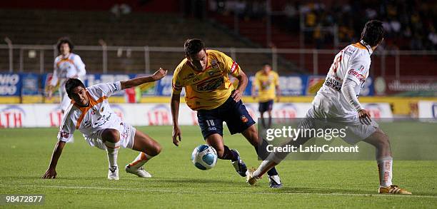 Morelia's player Gabriel Rey vies for the ball with Alejandro Arguello and Alan Zamora of Jaguares during their match as part of the 2010 Bicentenary...