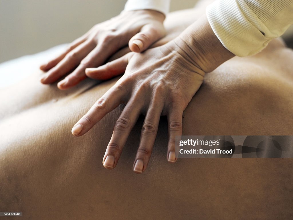 Hands on body giving massage.
