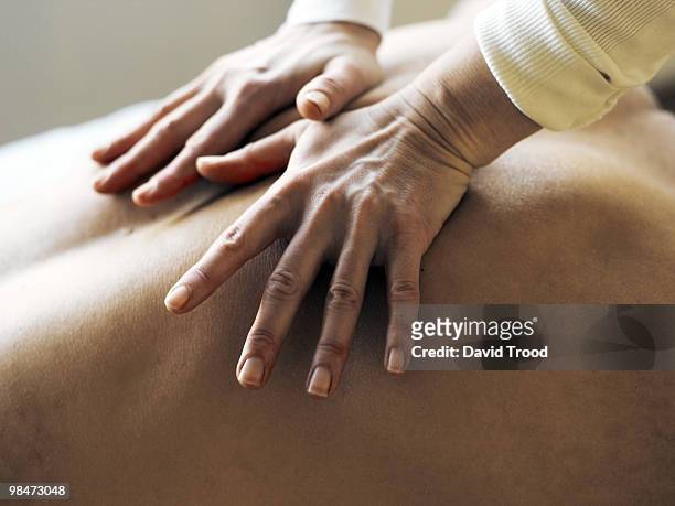 hands on body giving massage. - david trood stock pictures, royalty-free photos & images