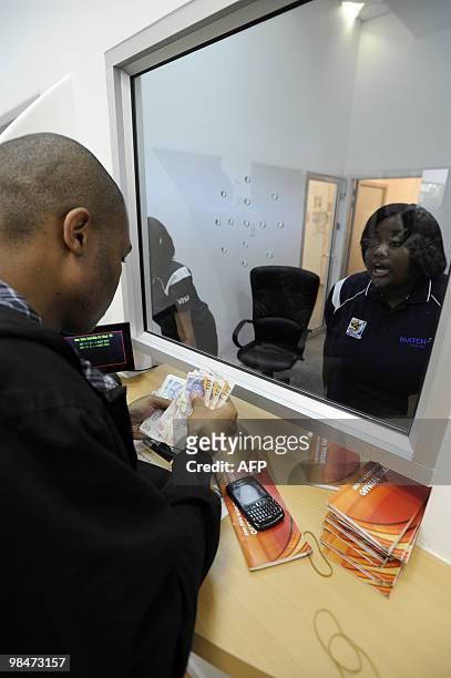 Man pays at a booking office as he purchases official 2010 FIFA World Cup tickets on April 15, 2010 at the Maponya shopping mall in Soweto during the...