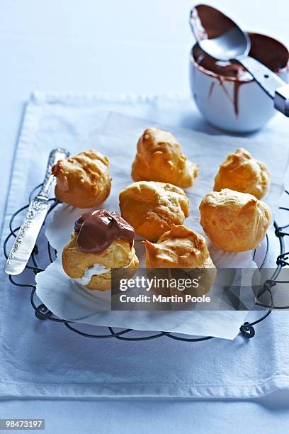 profiteroiles on baking rack being made up - profiterole stock pictures, royalty-free photos & images