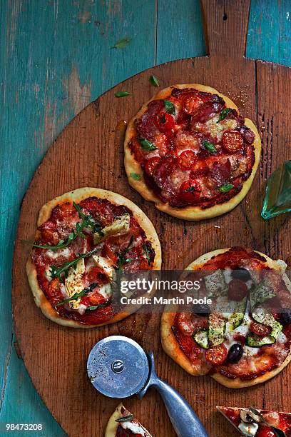 mini pizzas on wooden board - martin poole stock pictures, royalty-free photos & images