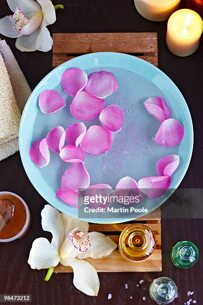 water with rose petals and essential oils - candle overhead stock-fotos und bilder
