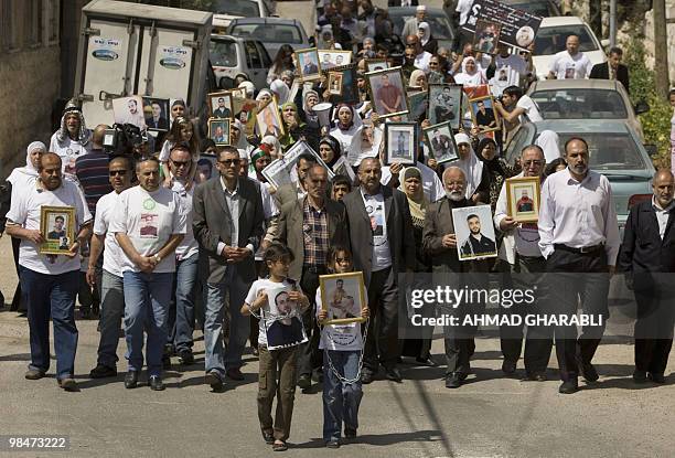 Palestinians hold pictures of their relatives held in Israeli jails during a protest in east Jerusalem on April 15, 2010 ahead of Prisoner Day. The...