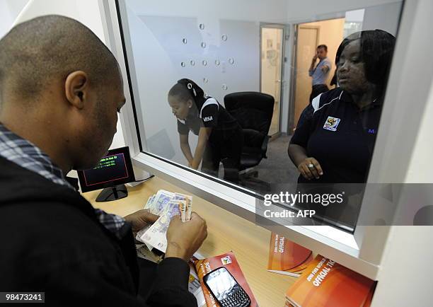 Man pays at a booking office as he purchases official 2010 FIFA World Cup tickets on April 15, 2010 at the Maponya shopping mall in Soweto during the...