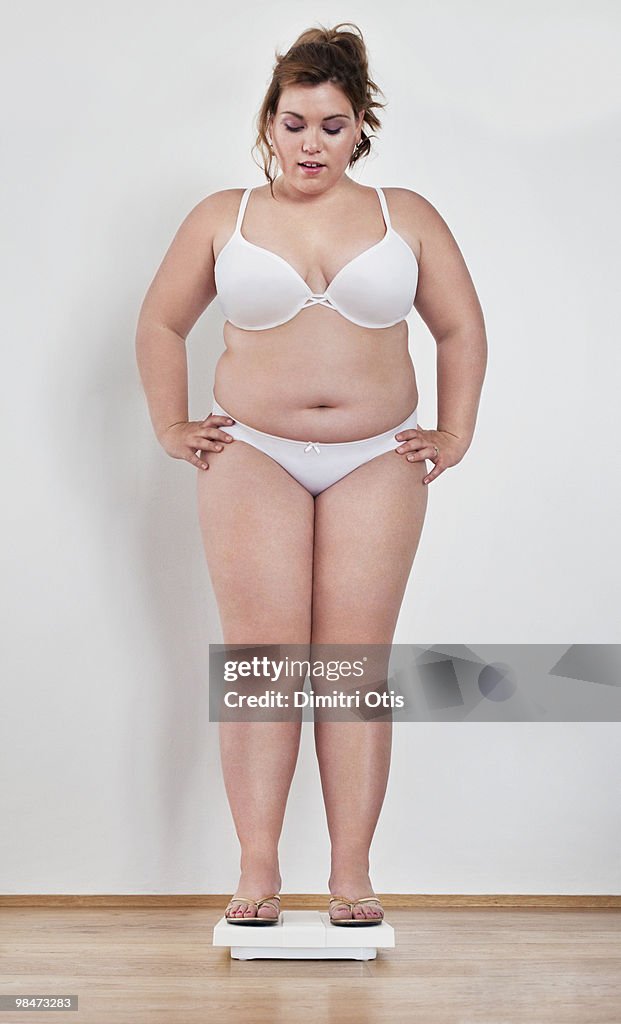 Young plus-size woman on scale