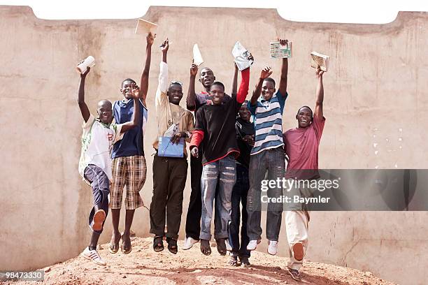 students jumping outside school - bamako stock-fotos und bilder