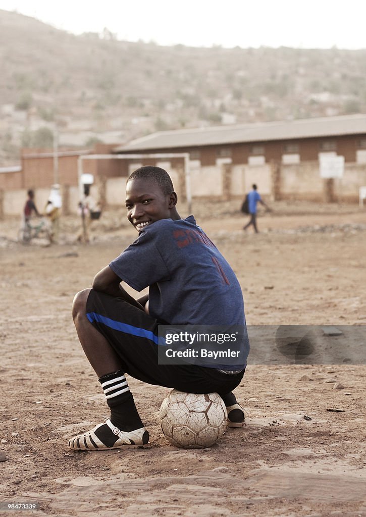 Young man sitting on football