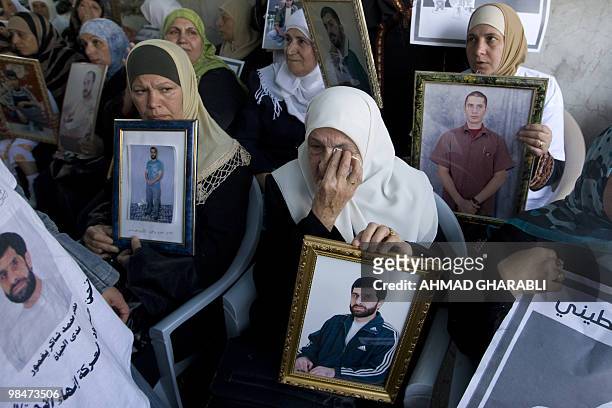Palestinians hold pictures of their relatives held in Israeli jails during a protest in east Jerusalem on April 15, 2010 ahead of Prisoner Day. The...