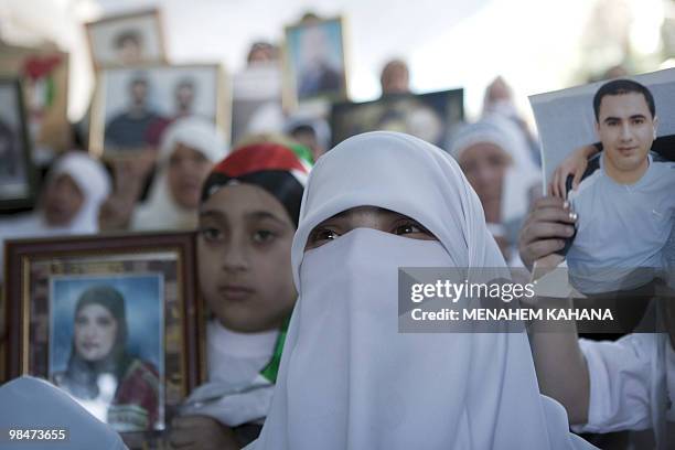 Palestinian women hold pictures of relatives held in Israeli jails during a protest in east Jerusalem on April 15, 2010 to demand their release ahead...