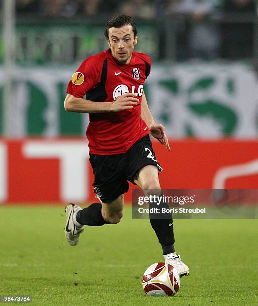 Simon Davies of Fulham runs with the ball during the UEFA Europa League quarter final second leg match between VfL Wolfsburg and Fulham FC at...
