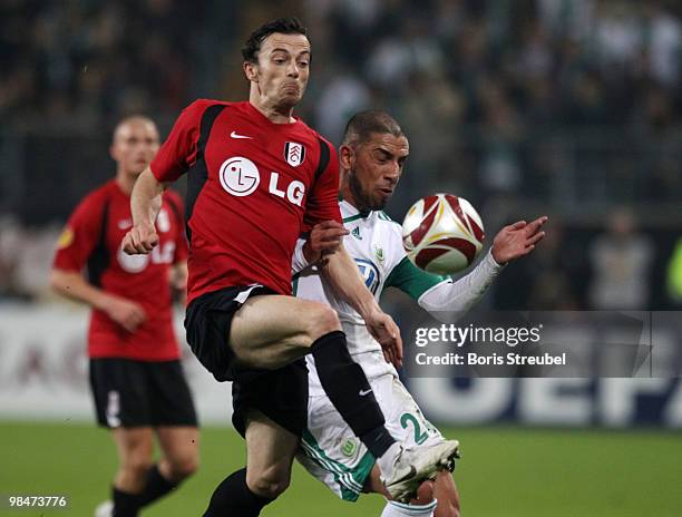 Ashkan Dejagah of Wolfsburg battles for the ball with Simon Davies of Fulham during the UEFA Europa League quarter final second leg match between VfL...