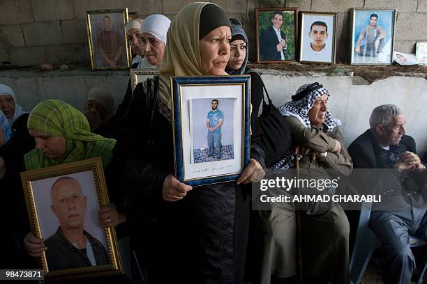 Palestinians hold pictures of their relatives held in Israeli jails during a protest in east Jerusalem on April 15, 2010 ahead of Prisoner Day. The...