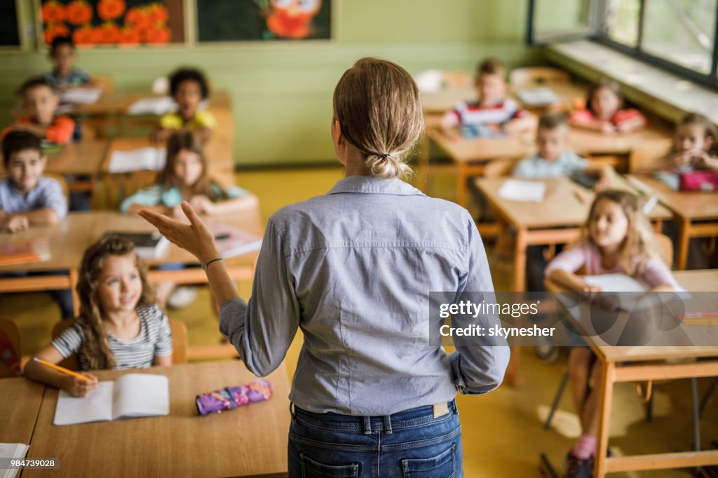 Heckansicht des einen weiblichen Volksschullehrer eine Lektion im Unterricht zu geben.
