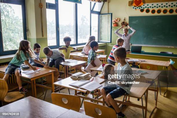 chaos in the classroom of elementary school! - naughty kids in classroom stock pictures, royalty-free photos & images