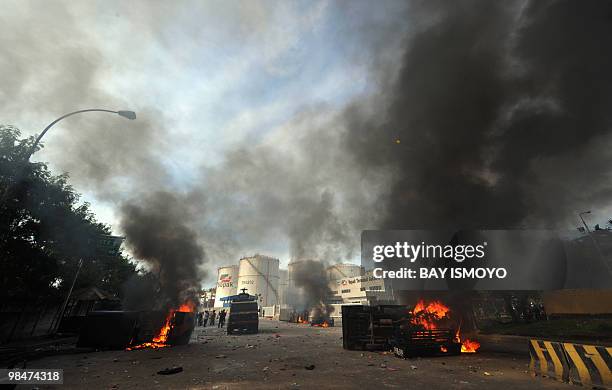 Vehicles belonging to the city's public order force burn during bloody clashes which broke out in Jakarta over over the demolition of a cemetery...