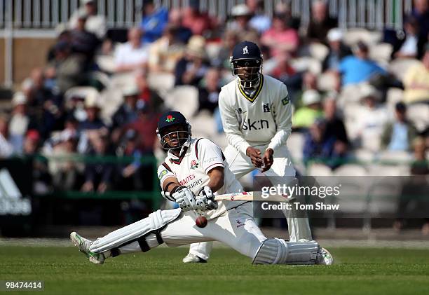 Ashwell Prince of Lancashire sweeps the ball during the LV County Championship match between Lancashire and Warwickshire at Old Trafford on April 15,...