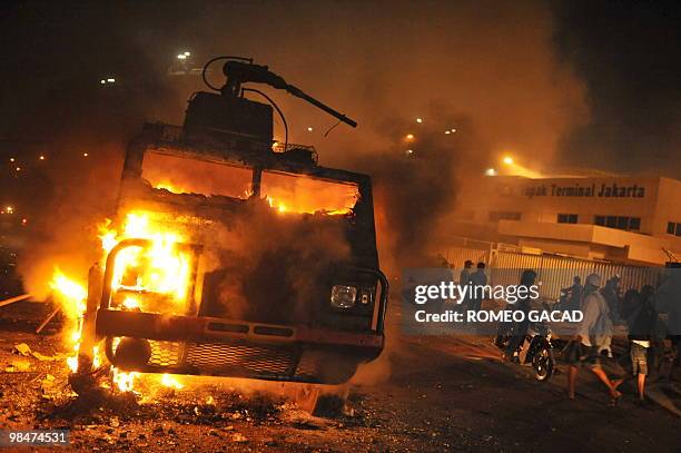 Police water canon truck burns after some 70 police vehicles were torched by demonstrators during a clash with police near a cemetery outside...