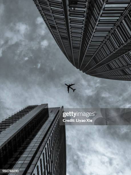 skyscraper with a airplane silhouette - xie liyao stock pictures, royalty-free photos & images