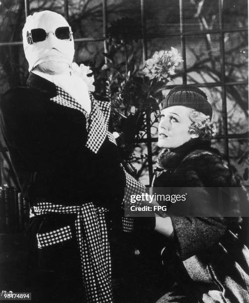 English actor Claude Rains plays the titular genius, with Gloria Stuart as his fiancee, in the film 'The Invisible Man', 1933.